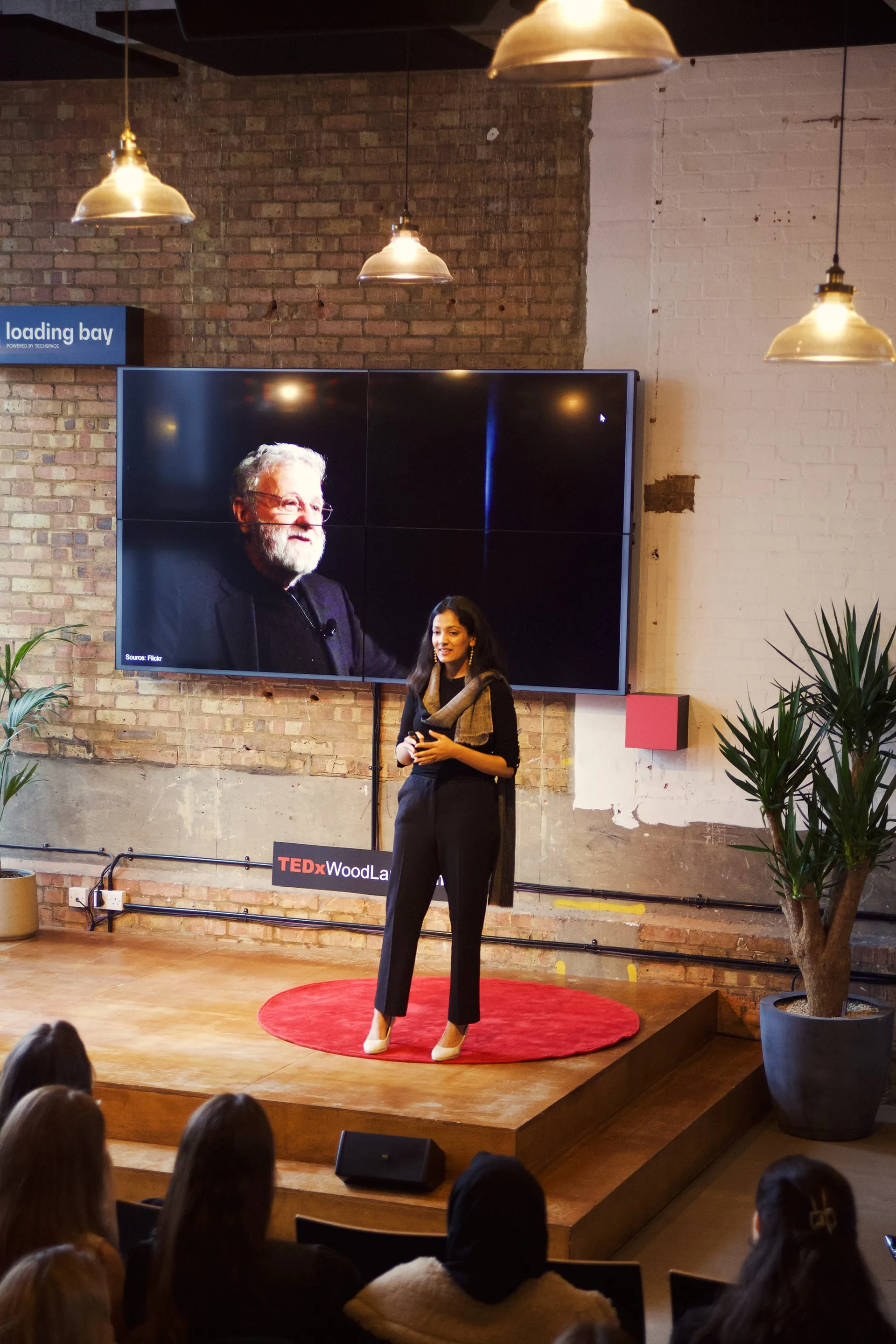 Disha Mittal speaking on stage at a TEDx event